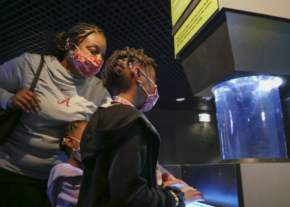 Adult and child interacting with micro plastics cyclone recreating how microplastics are moved around in water