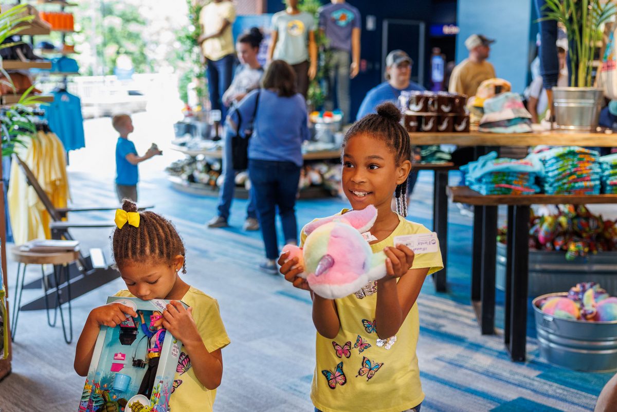 A girl holds a plush toy in the aquarium gift shop