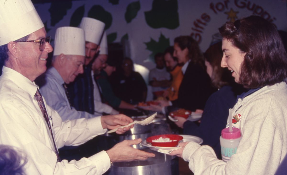 Jackson Andrews serves food to Aquarium staff members during a holiday event